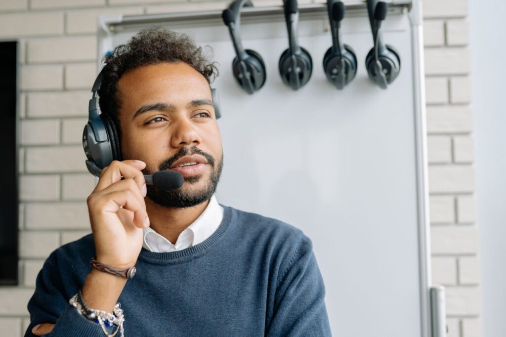 A man with a headset working in a call center, looking attentively ahead.